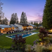 backyard of luxury home at twilight with outdoor lighting